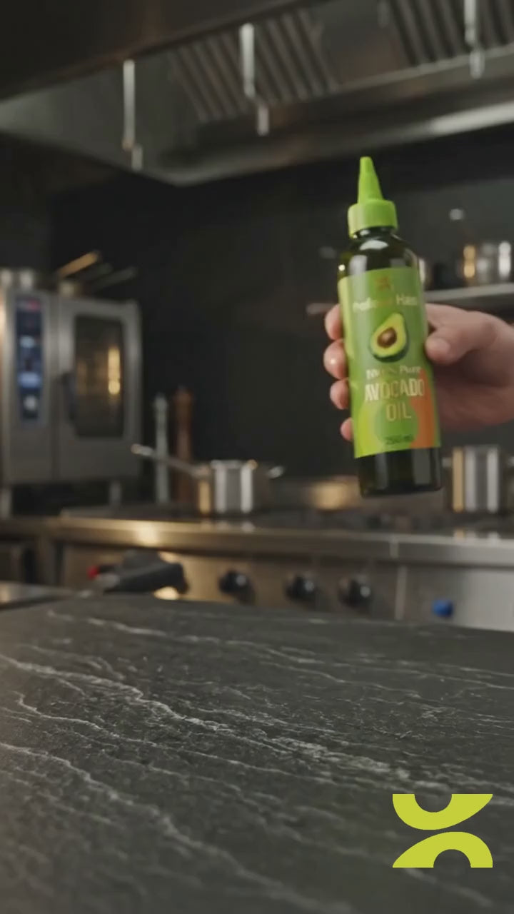 Mano sirviendo Aceite de Aguacate Profesor Hass 250 mL tapa pico sobre la estufa